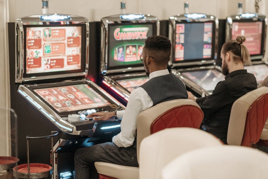 Men sitting in front of a slot machine